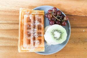 gaufre avec la glace crème et fruit ou Lait la glace crème avec gaufre, grain de raisin et kiwi fruit photo