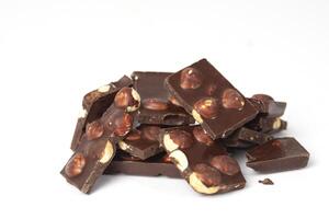 pièces de Chocolat avec des noisettes fermer isolé sur blanc Contexte. endroit pour texte photo