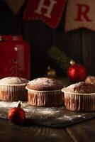 Chocolat muffins avec en poudre sucre sur Haut sur une noir Contexte. Noël décoration . encore la vie proche en haut. nourriture photo. photo