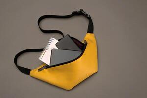 Jaune ceinture sac pour femmes et Hommes sur une foncé avec accessoires bloc-notes, Puissance banque et téléphone photo