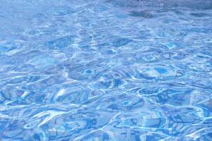 bleu l'eau dans le bassin en dessous de le Soleil. abstrait Contexte de l'eau reflets sur le surface. photo