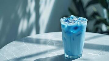 délicieux bleu matcha boisson sur une lumière gris table dans une verre photo