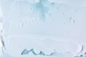 abstrait cosmétique Contexte fabriqué de blanc crème sur une bleu Contexte. photo
