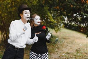 mime artiste soufflant une bulle par baguette magique sur vert Contexte photo