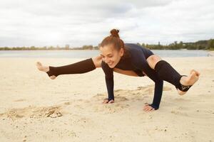 magnifique âge moyen fille Faire yoga des exercices sur le rive de une magnifique Lac sur une ensoleillé l'automne journée photo