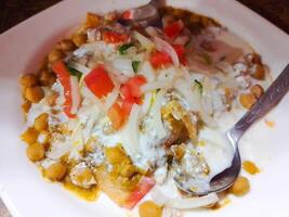 cholé samosa chaat avec yaourt, oignon et patates. populaire rue nourriture dans Inde et Pakistan photo