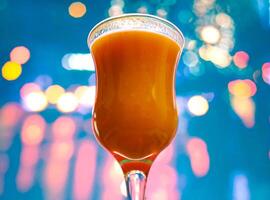 Orange jus dans bar verre dans de face de floue clignotant lumières Contexte photo