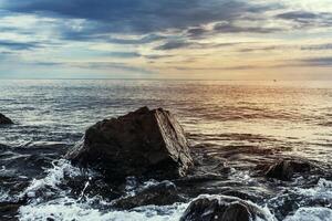 grand pierre sur une Contexte de mer le coucher du soleil photo