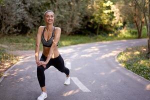 femme coureur élongation jambes avant exercice été parc Matin photo