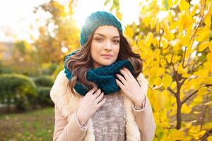 une magnifique Jeune fille des promenades par le l'automne parc sur le Contexte de vivement coloré feuilles photo