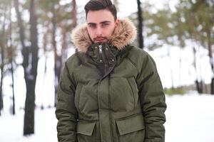 attrayant barbu homme permanent en plein air dans hiver saison forêt. photo