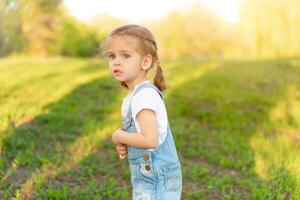 le peu fille est effrayé, perdu dans le parc. photo