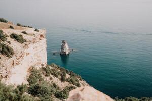 femme Voyage mer. content touristique prendre plaisir prise image en plein air pour souvenirs. femme voyageur regards à le bord de le falaise sur le mer baie de montagnes, partage Voyage aventure périple photo