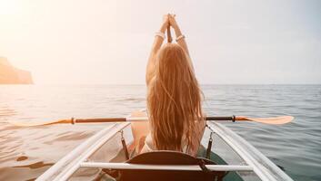 femme dans kayak retour voir. content Jeune femme avec longue cheveux flottant dans transparent kayak sur le cristal clair mer. été vacances vacances et de bonne humeur femelle gens relaxant ayant amusement sur le bateau photo