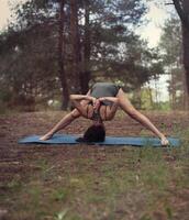 magnifique fille est engagé dans yoga dans le forêt photo