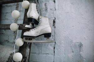 une paire de blanc cuir des sports patins pendre sur une corde sur le mur. bien Nouveau année esprit. magnifique calme Contexte photo