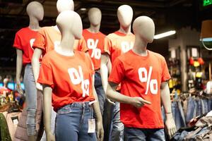 pourcentage signe peint sur une rouge T-shirt habillé sur une mannequin des stands dans défocalisé boutique photo