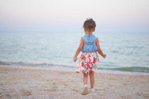 enfant en jouant le sable plage peu fille jouer triste seul été famille vacances photo