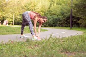 en forme femme chauffage en haut jambes avant fonctionnement des exercices permanent fonctionnement Piste dans été parc photo