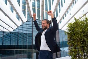 excité Jeune homme d'affaire dans costume célébrer la victoire bras élevé photo