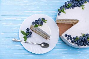 appétissant cheesecake gâteau biscuit oreiller décoré blanc crème myrtilles et menthe des stands sur en bois bleu rustique table photo