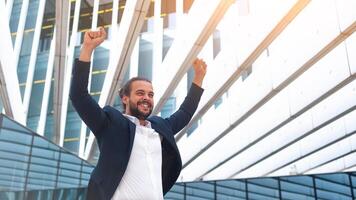 excité Jeune homme d'affaire dans costume célébrer la victoire bras élevé photo