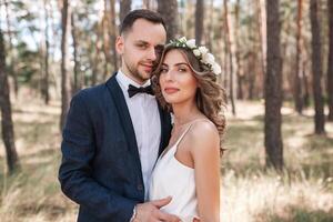 la mariée et jeune marié à mariage journée en marchant en plein air sur été la nature. de mariée couple, content nouveau marié femme et homme embrassement dans vert parc. aimant mariage couple Extérieur. la mariée et jeune marié photo