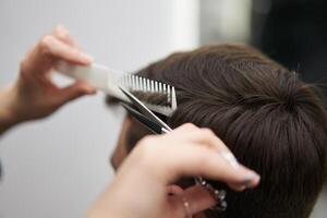 magnifique caucasien femme coiffeur Faire coiffure à client. photo