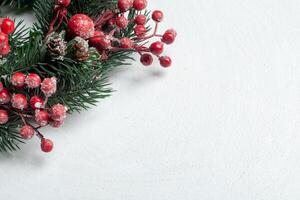Noël décoratif couronne de houx, lierre, du gui, cèdre et leyland feuille brins avec rouge baies plus de blanc Contexte. photo
