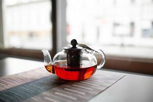 verre théière de revigorant Frais aromatique thé sur une en bois photo