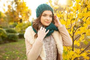 une magnifique Jeune fille des promenades par le l'automne parc sur le Contexte de vivement coloré feuilles photo