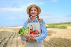 femme agriculteur paille chapeau tablier permanent les terres agricoles souriant femelle agronome spécialiste agriculture secteur agroalimentaire content positif caucasien ouvrier agricole champ photo