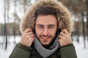 attrayant barbu homme permanent en plein air dans hiver saison forêt. photo