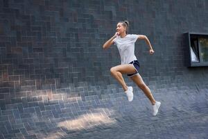 femme avec en forme corps sauter et fonctionnement contre noir mur Contexte photo