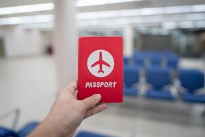 main en portant passeport à le aéroport à embarquement portail. photo