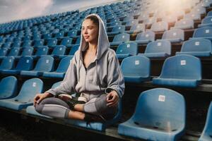 Jeune attrayant femme pratiquant yoga, séance dans padmasana exercer, lotus pose sur méditation session, travail en dehors portant tenue de sport photo