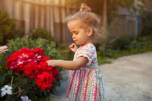 portrait de magnifique peu fille avec des roses fleurs photo