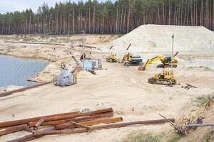 le sable carrière exploitation minière industrie équipement excavatrice tracteur permanent le sable terre près Lac l'eau photo