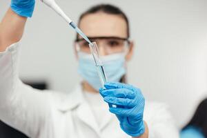 médical recherche laboratoire. une scientifique travaux avec une pipette et une tester tube. scientifique laboratoire de biotechnologie, développement de médicament et recherche dans chimie, biochimie et expériences photo