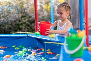 enfant pêcheur contagieux Plastique jouet poisson sur bassin amusement parc été journée photo