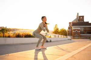 sportif femme Faire sauter squats des exercices sur escaliers dans parc. poids formation sur le coucher du soleil. photo