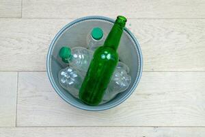 six différent Plastique et verre bouteilles dans le Bureau poubelle peut. écologie et recyclage de déchets de divers brut matériaux photo