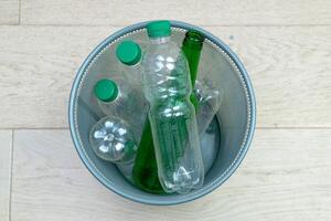 six différent Plastique et verre bouteilles dans le Bureau poubelle peut. écologie et recyclage de déchets de divers brut matériaux photo