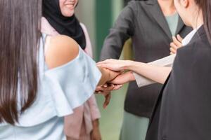 concepts de travail d'équipe réussis, hommes d'affaires avec les mains jointes en équipe, groupe de mains diverses se joignant, équipe de jeunes femmes d'affaires mettant leurs mains ensemble photo