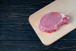 Haut vue de un pièces brut porc hacher steaks sur une Coupe planche. photo