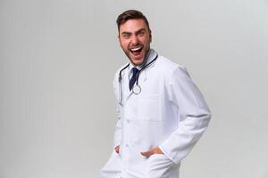 Jeune Beau moderne médecin dans une blanc médical robe des stands dans le studio sur une blanc Contexte. étudiant stagiaire de une médical université. photo