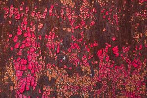le fissuré rouge peindre sur un vieux métallique surface. photo