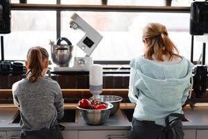 méconnaissable mère avec fille faire Ménage corvées dans le cuisine ensemble. photo