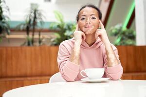 noir africain américain femme avec vitiligo pigmentation peau problème intérieur habillé rose sweat à capuche photo