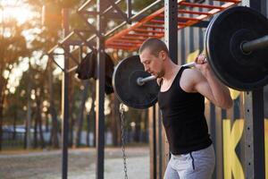 homme avec haltère Extérieur Gym sur la nature dans parc. photo